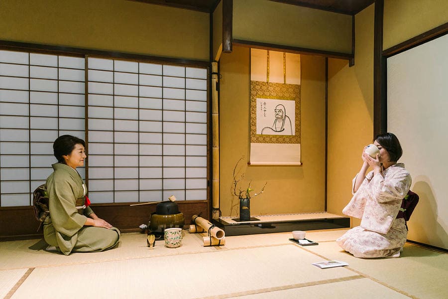 Tea master bowing during a traditional Kyoto tea ceremony in a tea room